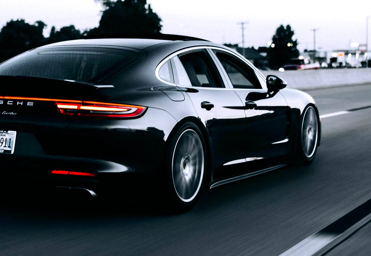 Black performance sedan driving after completed service