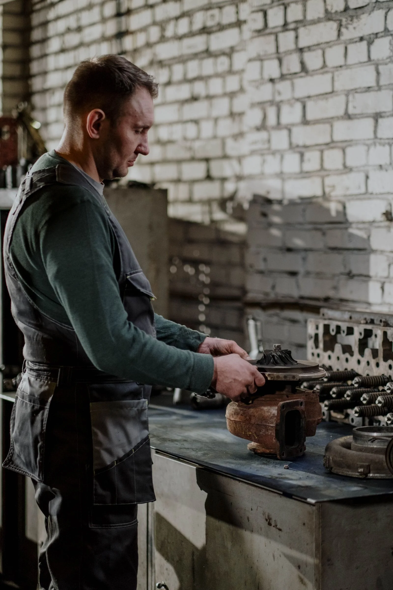 Technician inspecting an engine cylinder head at a workbench