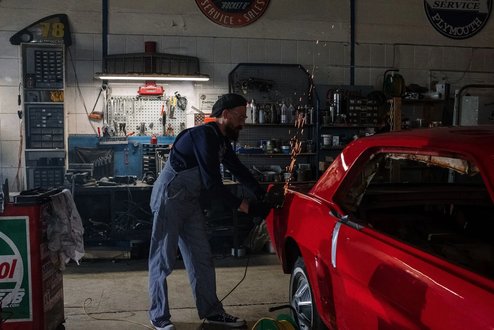 Technician completing restoration work on a red classic car