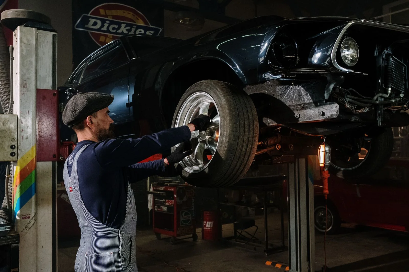 Technician servicing the front suspension on a lifted vehicle
